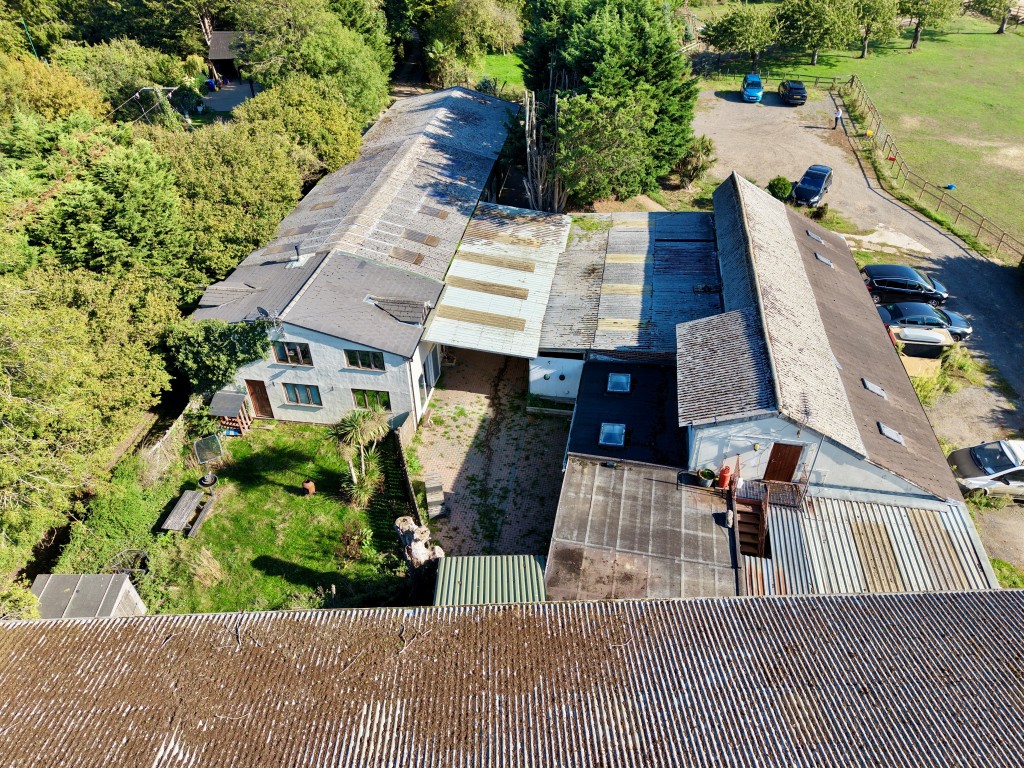 Lot: 80 - EQUESTRIAN FACILITY - INDOOR MANÈGE, STABLES, PADDOCKS AND ACCOMMODATION - Aerial view of buildings from above sand school